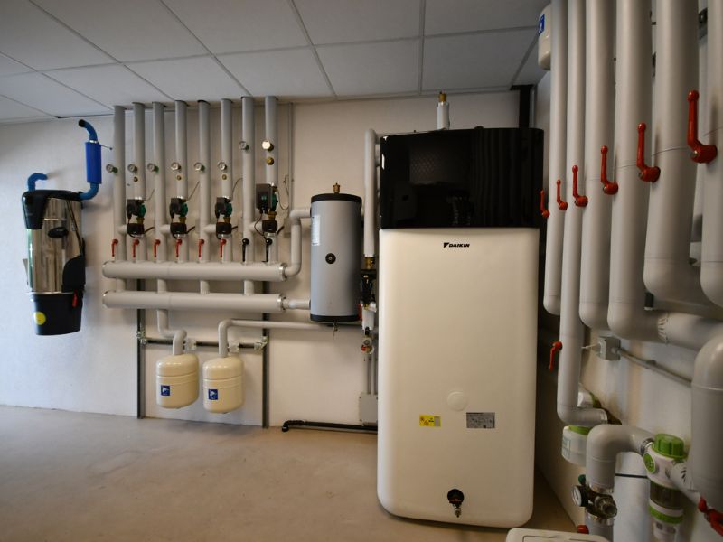 Locale tecnico con impianto idrico centralizzato, tubazioni coibentate, collettori, valvole, pompe e serbatoi per la distribuzione e la gestione dell’acqua.